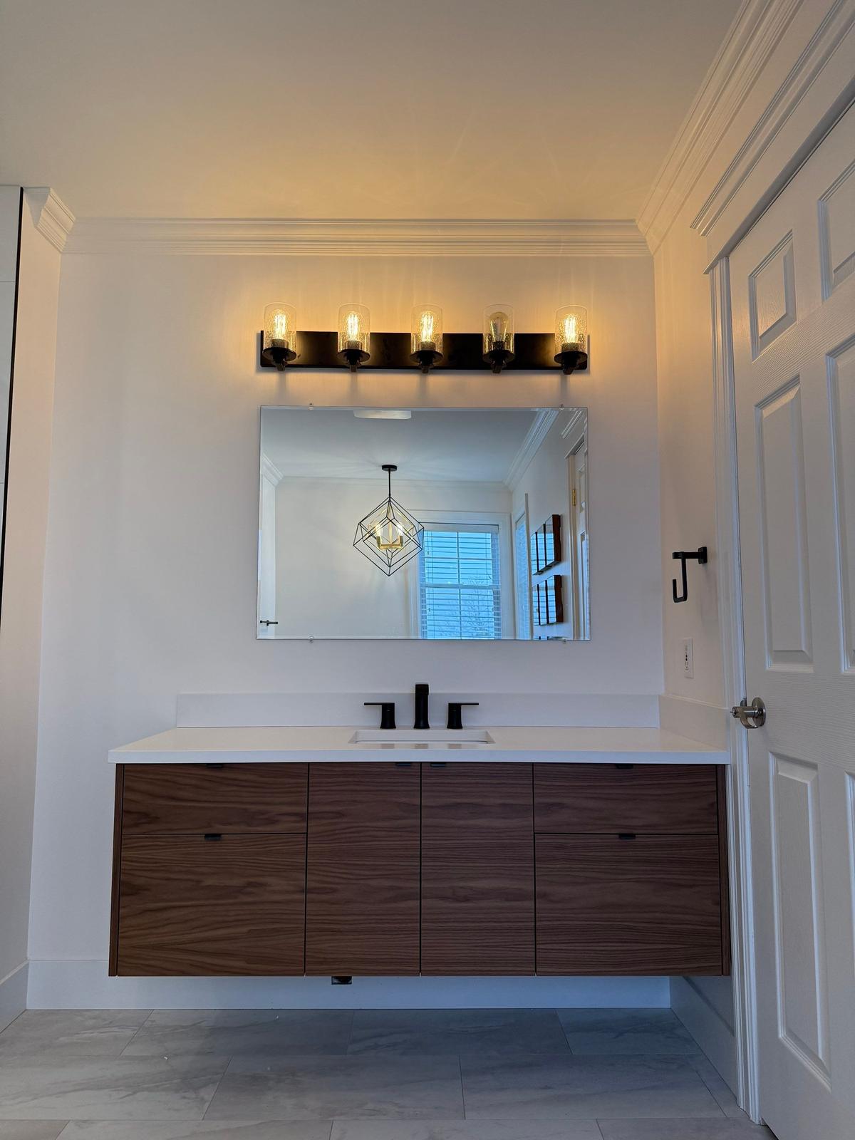 The finished Motion Lane bathroom — floating walnut vanity and black fixtures.