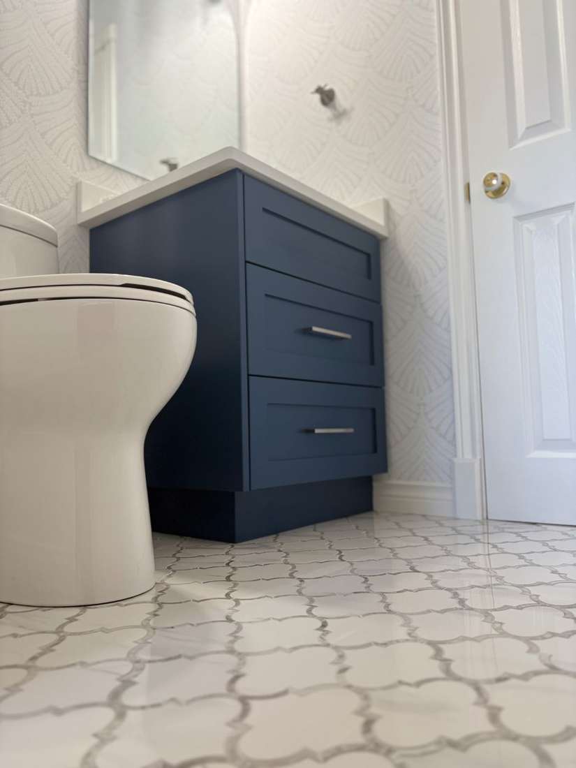Kensington powder room — arched mirror and textured wallpaper.