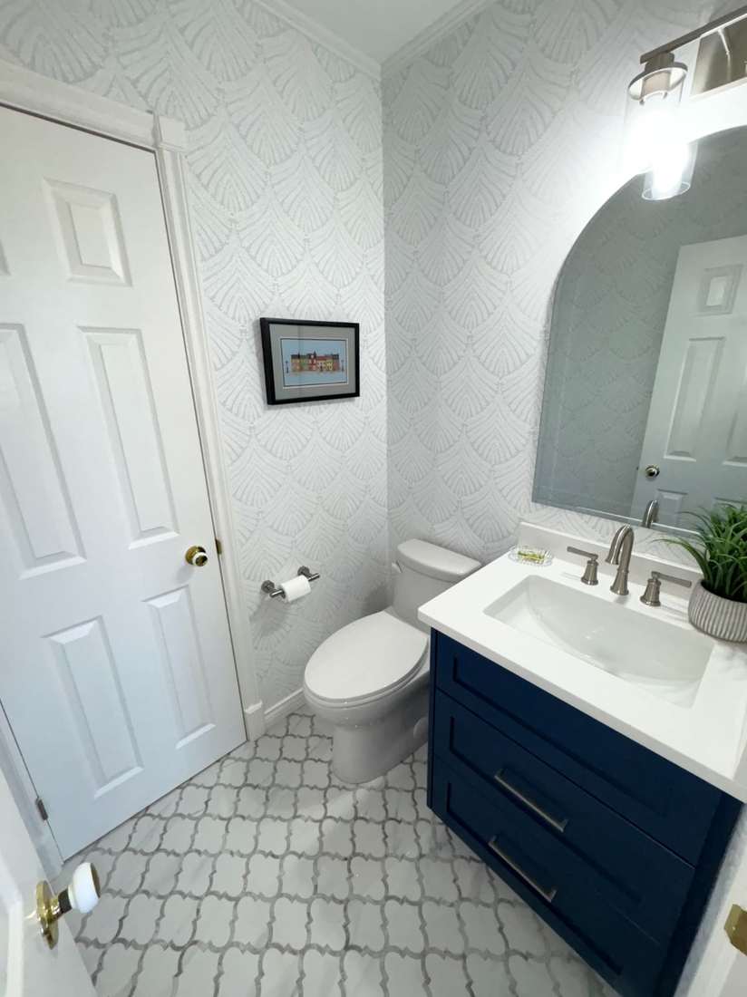 Kensington powder room — vanity, sconce and wallpaper detail.
