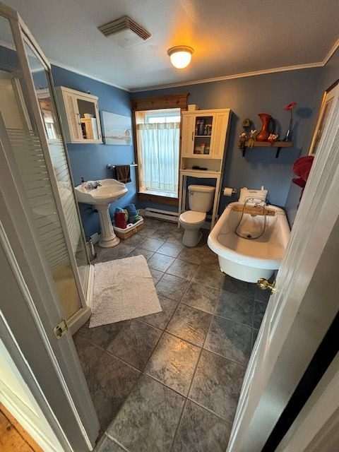 The Bond bathroom before renovation — a dated layout with a corner shower, pedestal sink, and old tub.