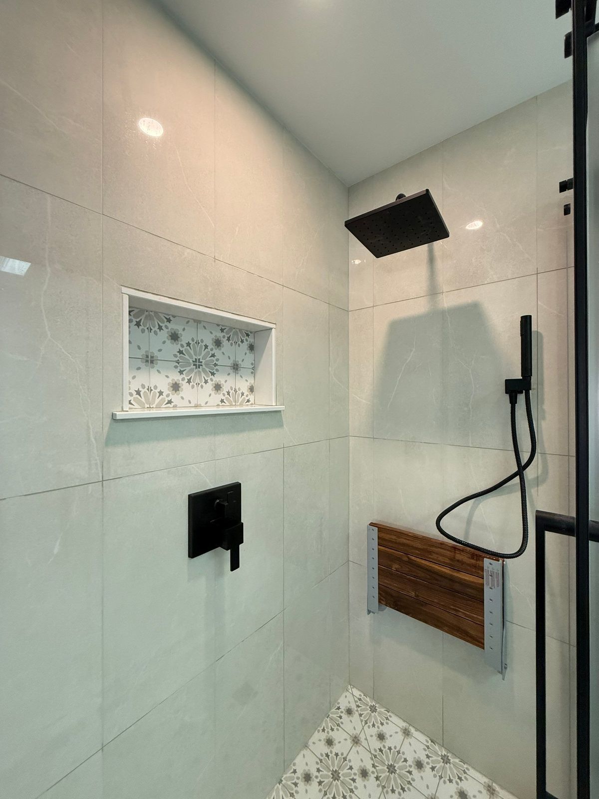 Baker Street shower tiled niche detail with black fixtures.