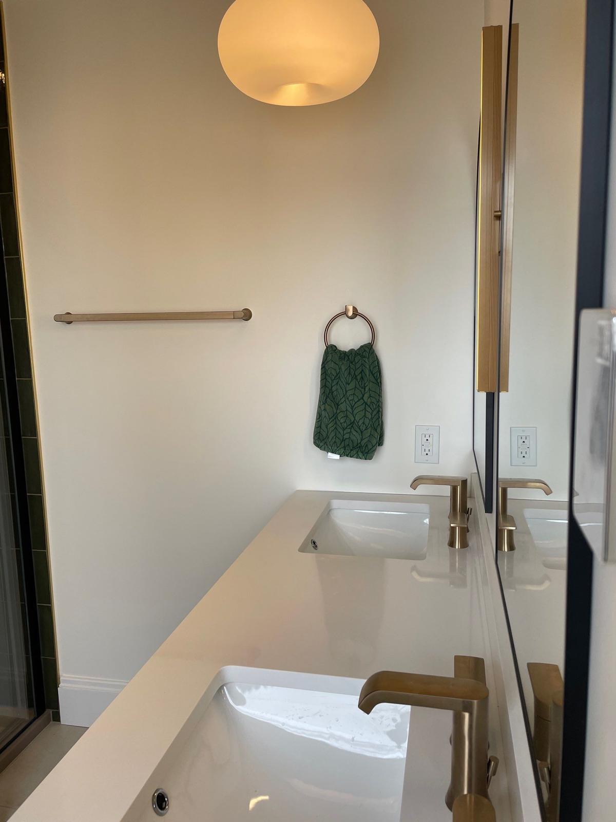 Newtown Road — brushed brass vanity fixtures and towel bar.