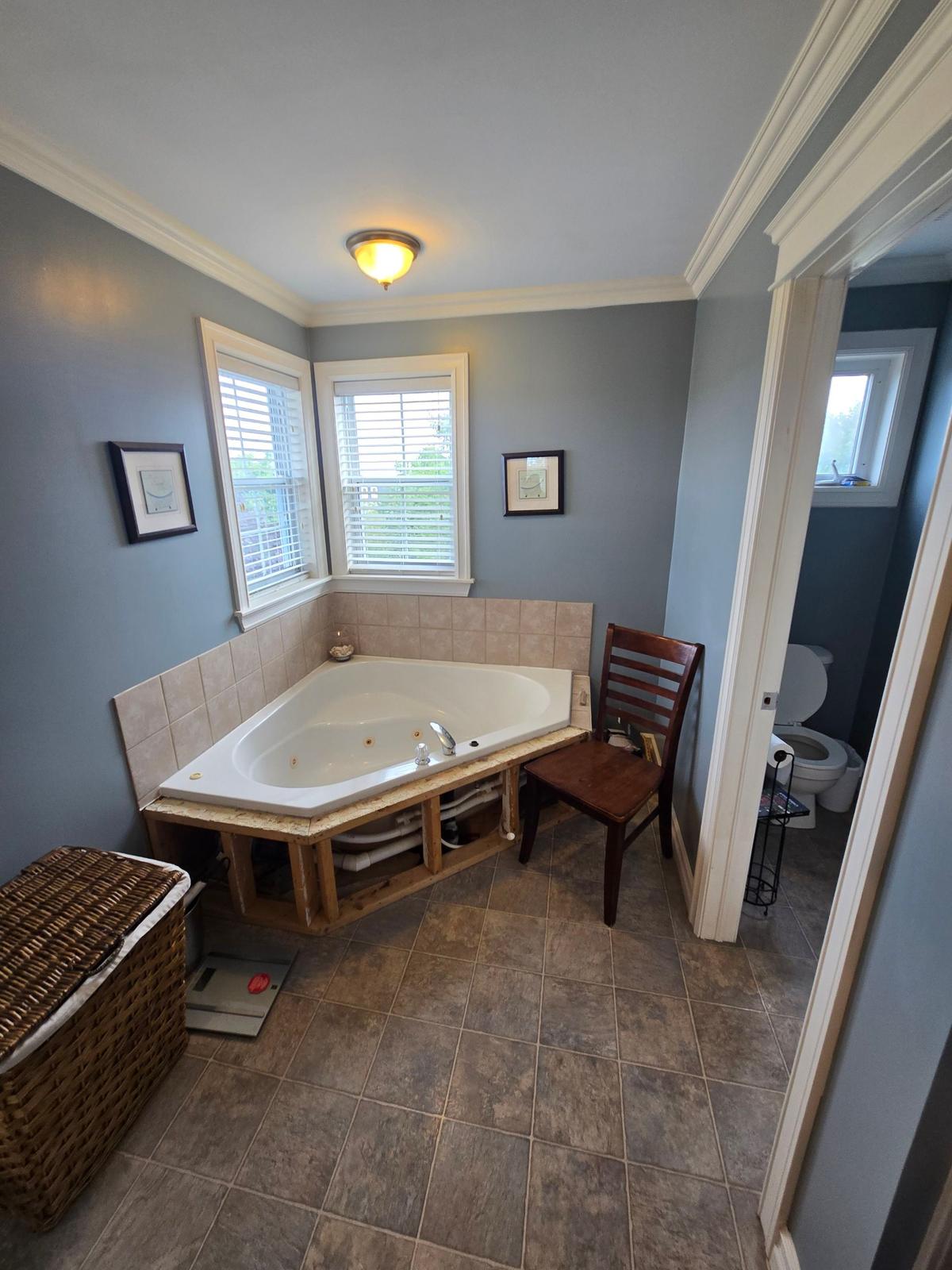Motion Lane bathroom before renovation — corner soaker tub mid-demolition.