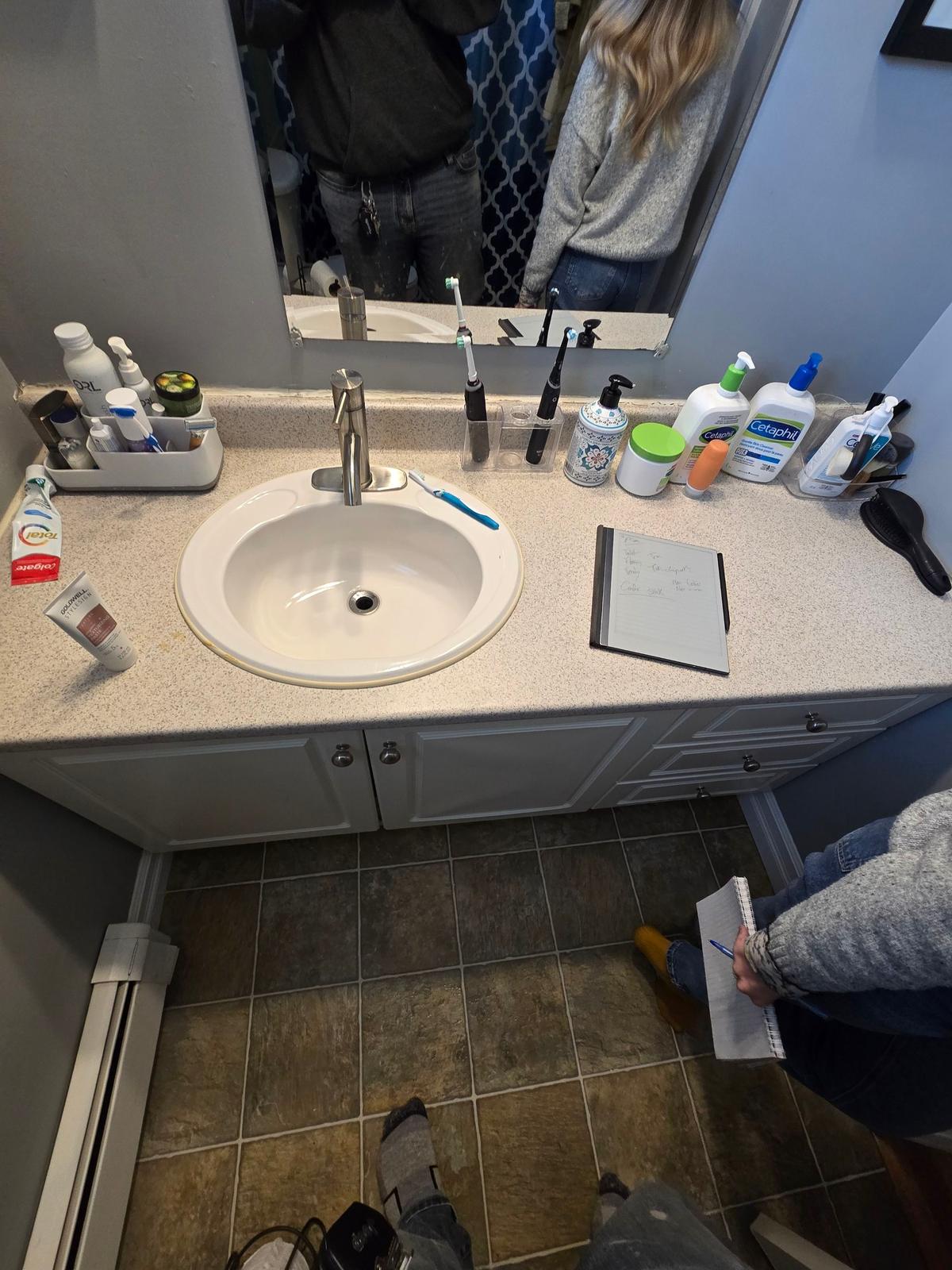 Motion Lane vanity and sink before renovation — original countertop and fixtures.