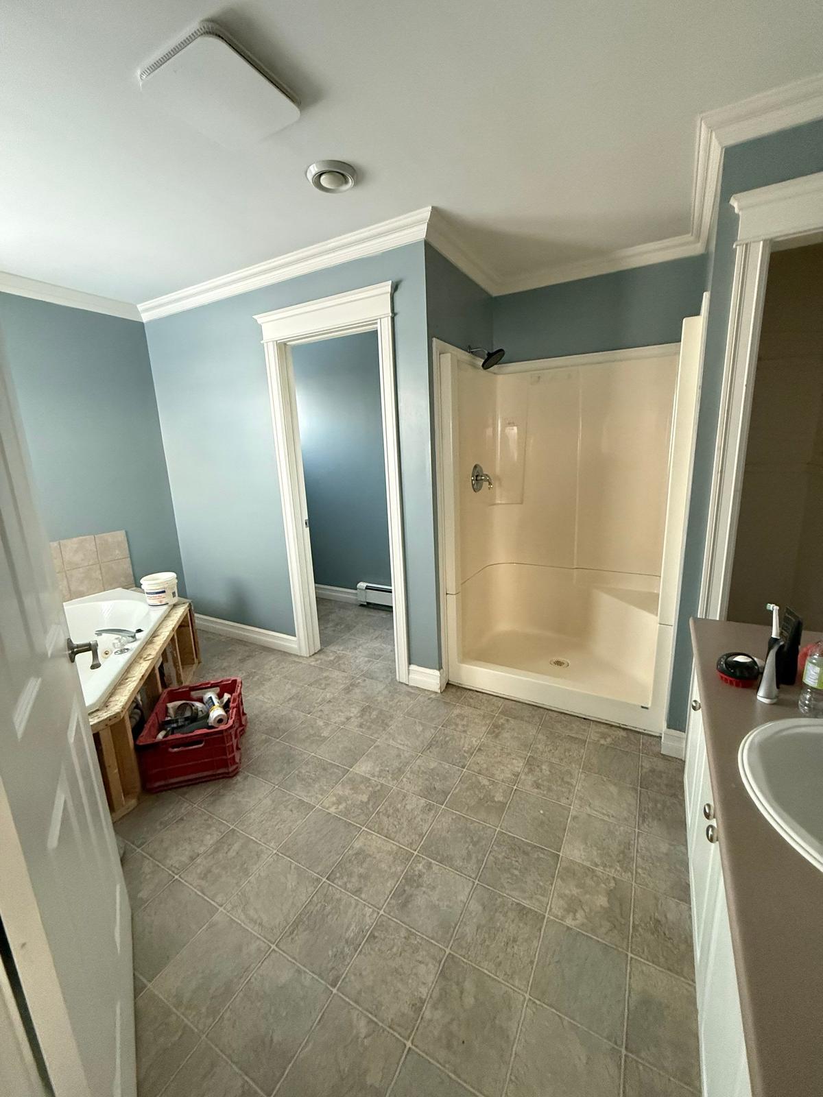 Motion Lane bathroom before renovation — full room view, corner tub and shower stall.